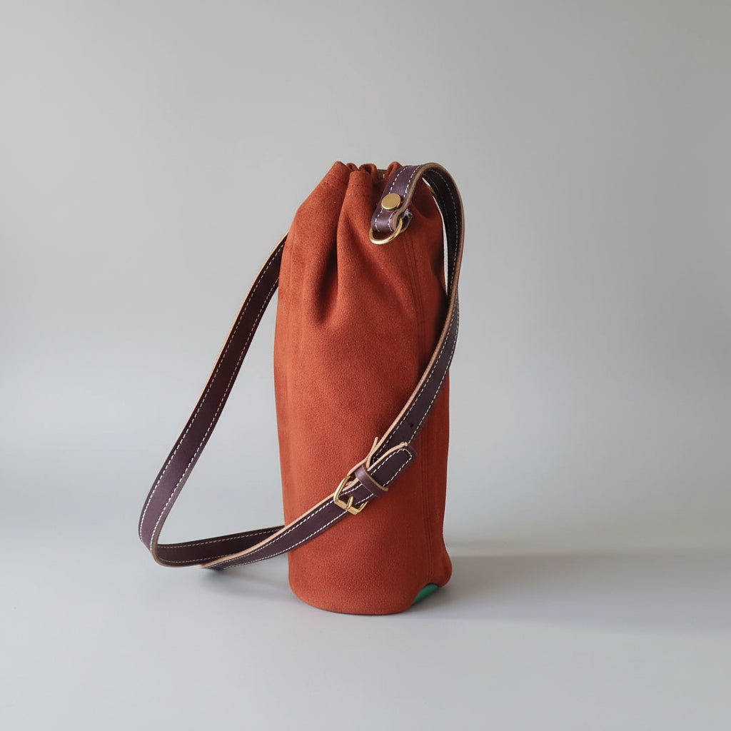 Porte-bouteille d'eau en cuir camel avec fond velours vert et bandoulière réglable