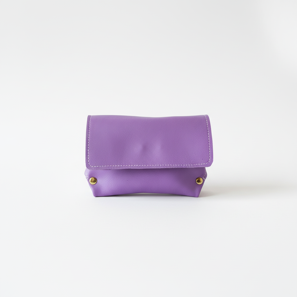 Pochette en cuir beige avec rivets dorés vue latérale sur fond blanc