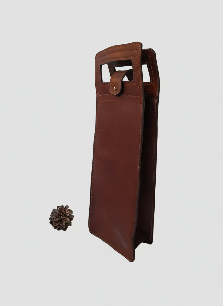 Porte-bouteille de vin artisanal en cuir de vachette marron avec poignée intégrée et fermeture à bouton de col doré, fabriqué à la main en France par MOOAKUIR
