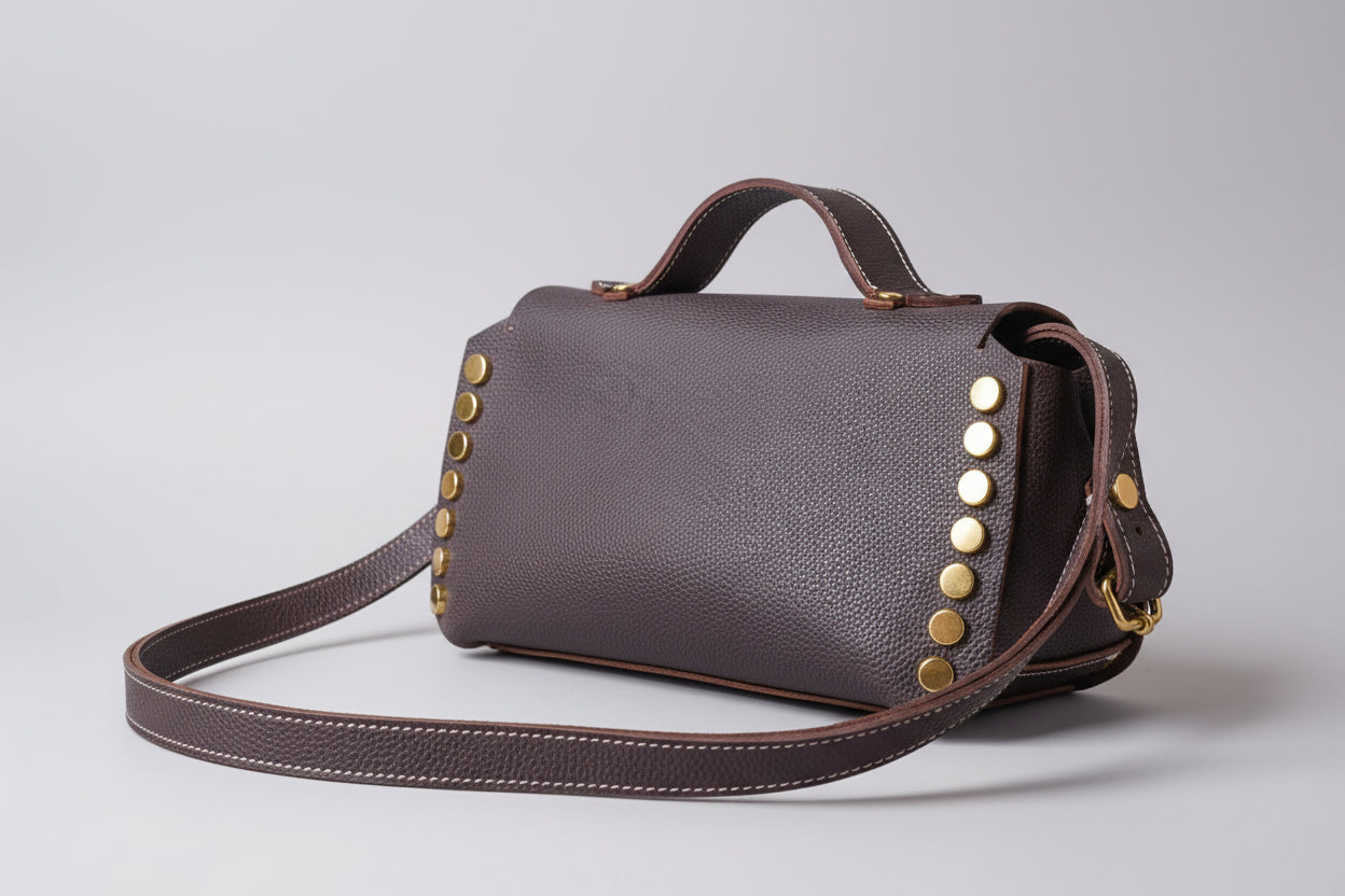 Sac à rivets en cuir grainé marron de vachette avec rivets dorés