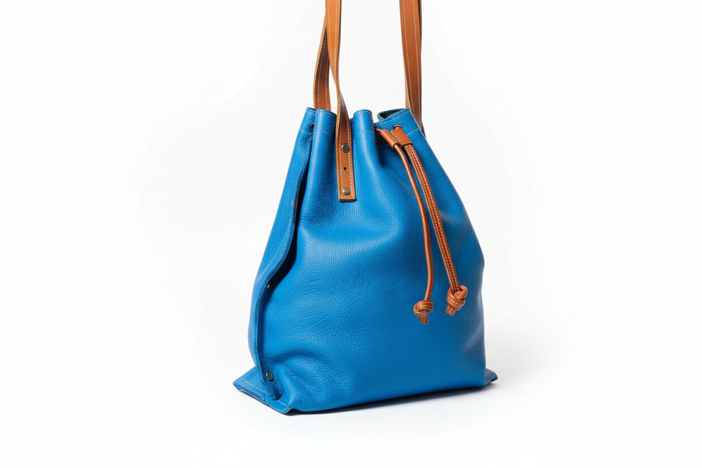 "Sac Liane bleu en cuir de veau avec liens de serrage et rivets dorés"